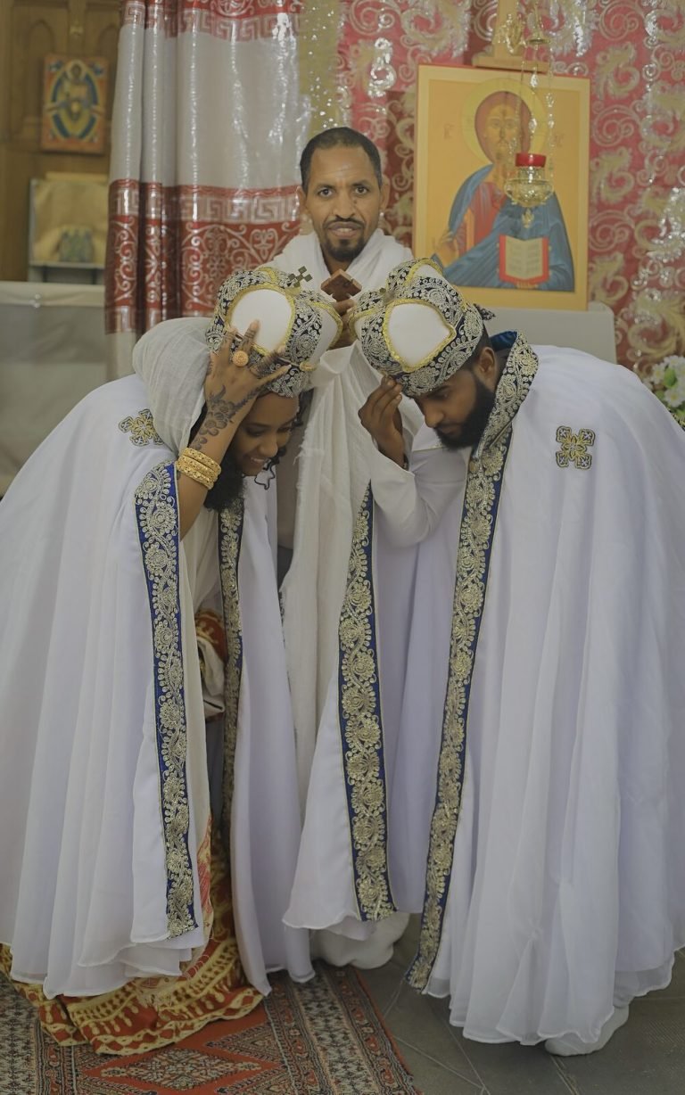 Le marié couronné, en cape brodée, devant une icône religieuse