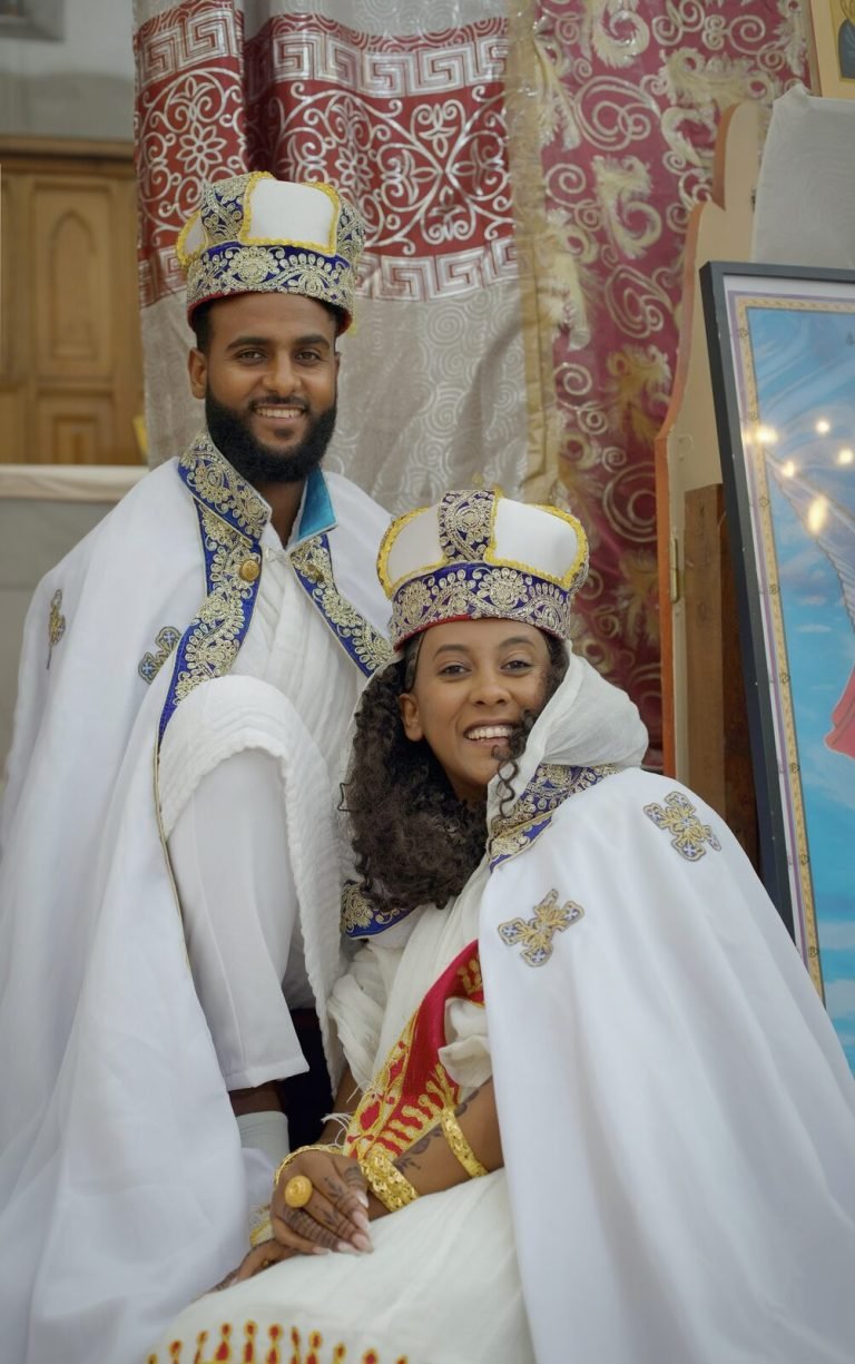 Les mariés assis se regardent en souriant, dans leurs capes de cérémonie