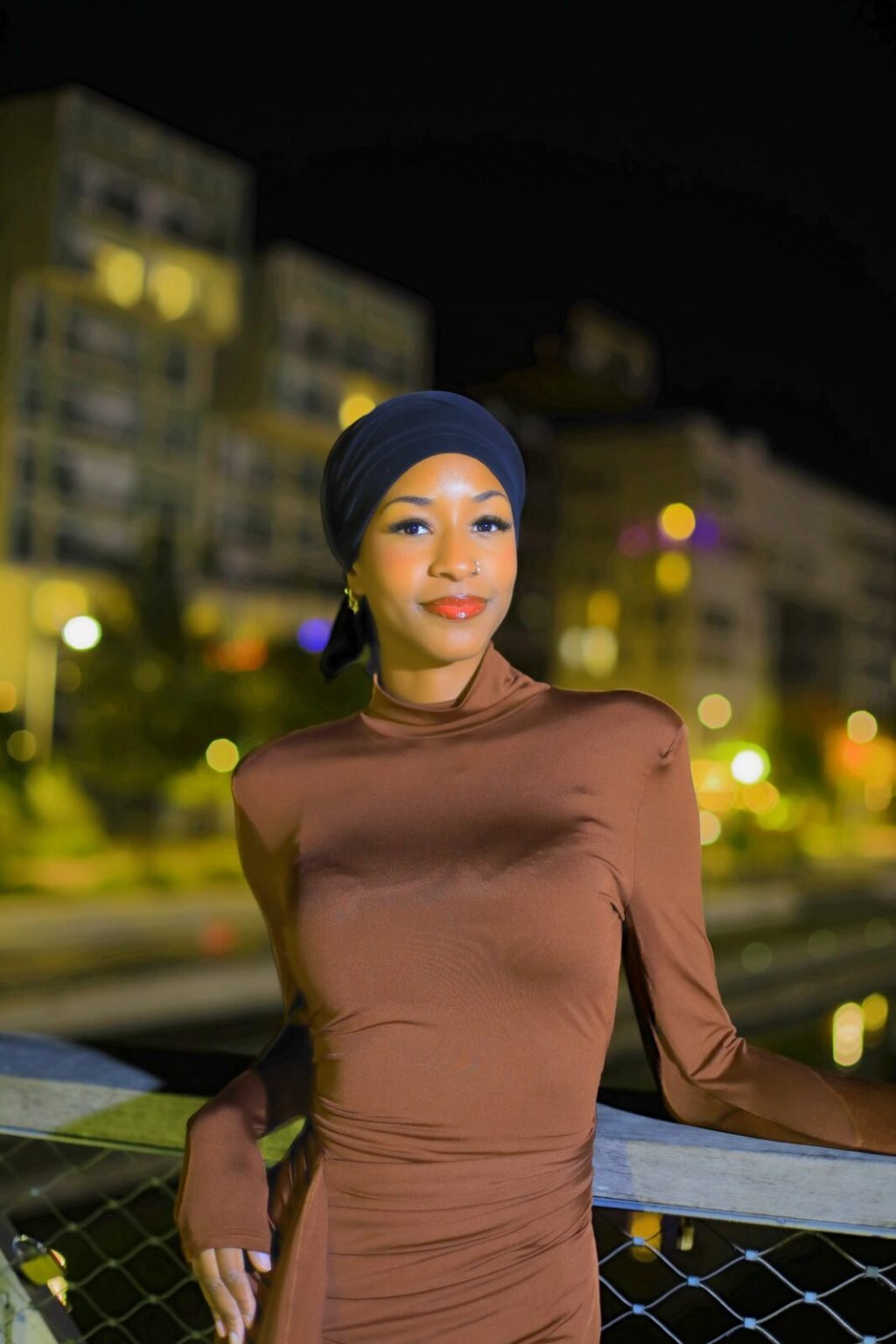 Portrait de nuit, haut marron, les lumières de la ville en arrière-plan