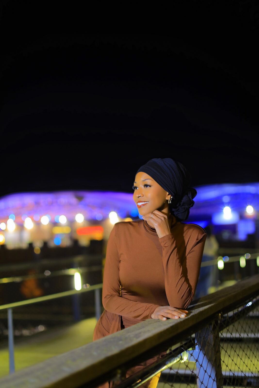 Portrait d'une invitée accoudée à une balustrade, lumières bleues de la nuit