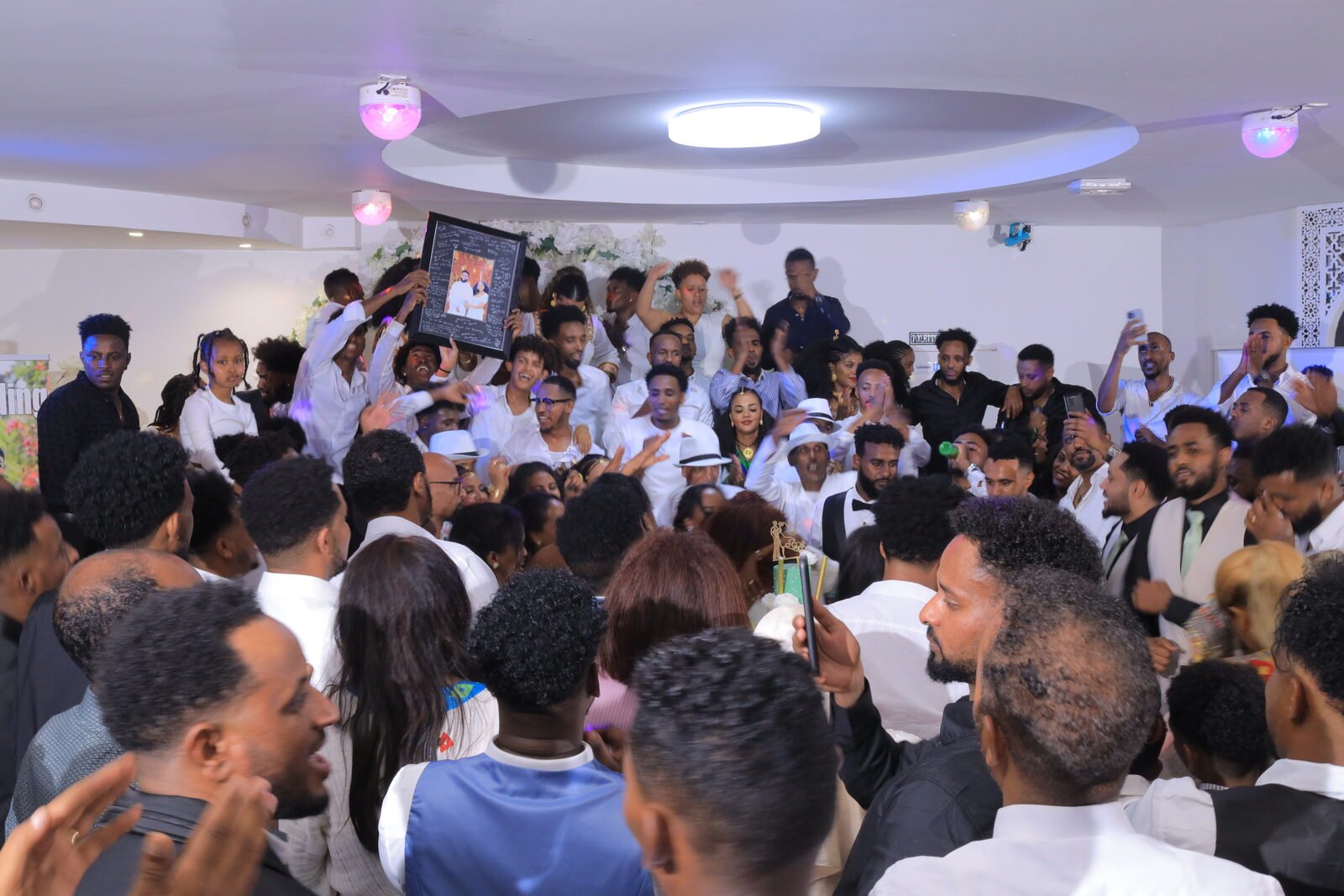 La salle comble pendant la fête, mains levées et sourires