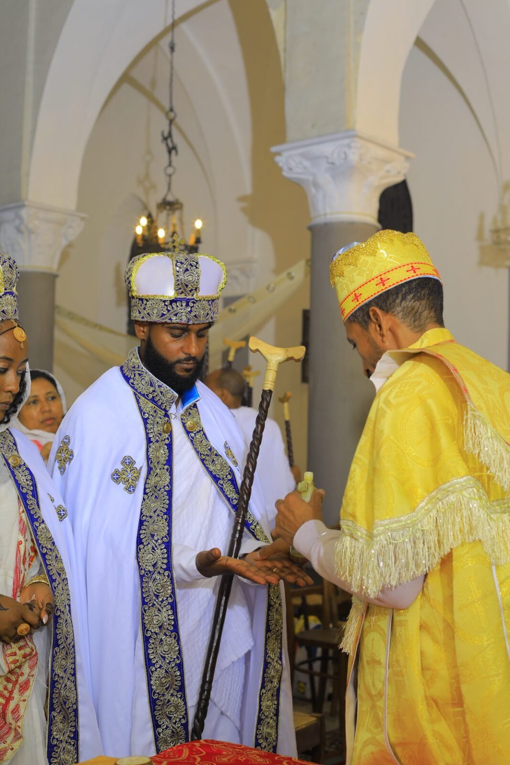 Le prêtre en chasuble dorée bénit les mariés couronnés