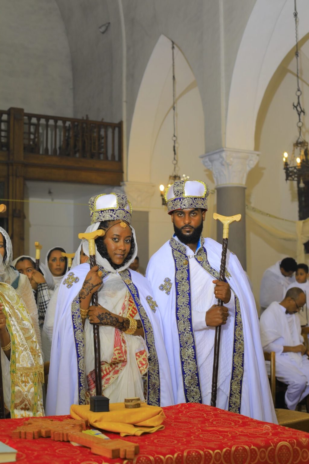 Les mariés entourés de leurs proches sous les arches de l'église