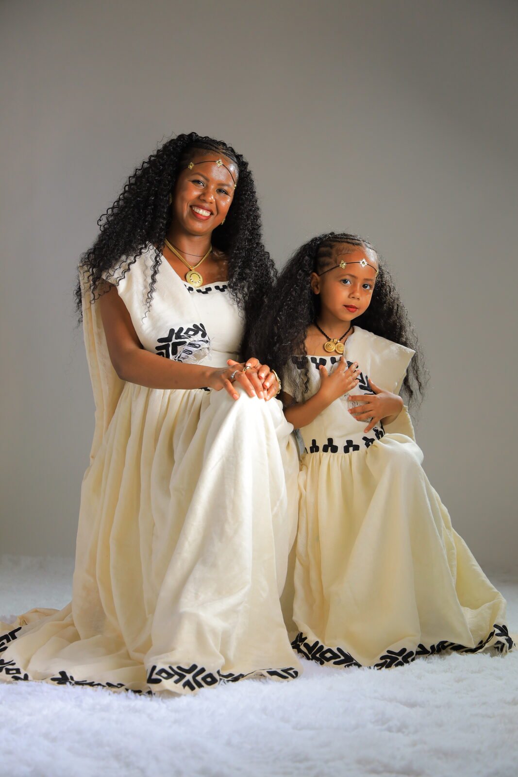 Une mère et sa fille en robes traditionnelles assorties, studio