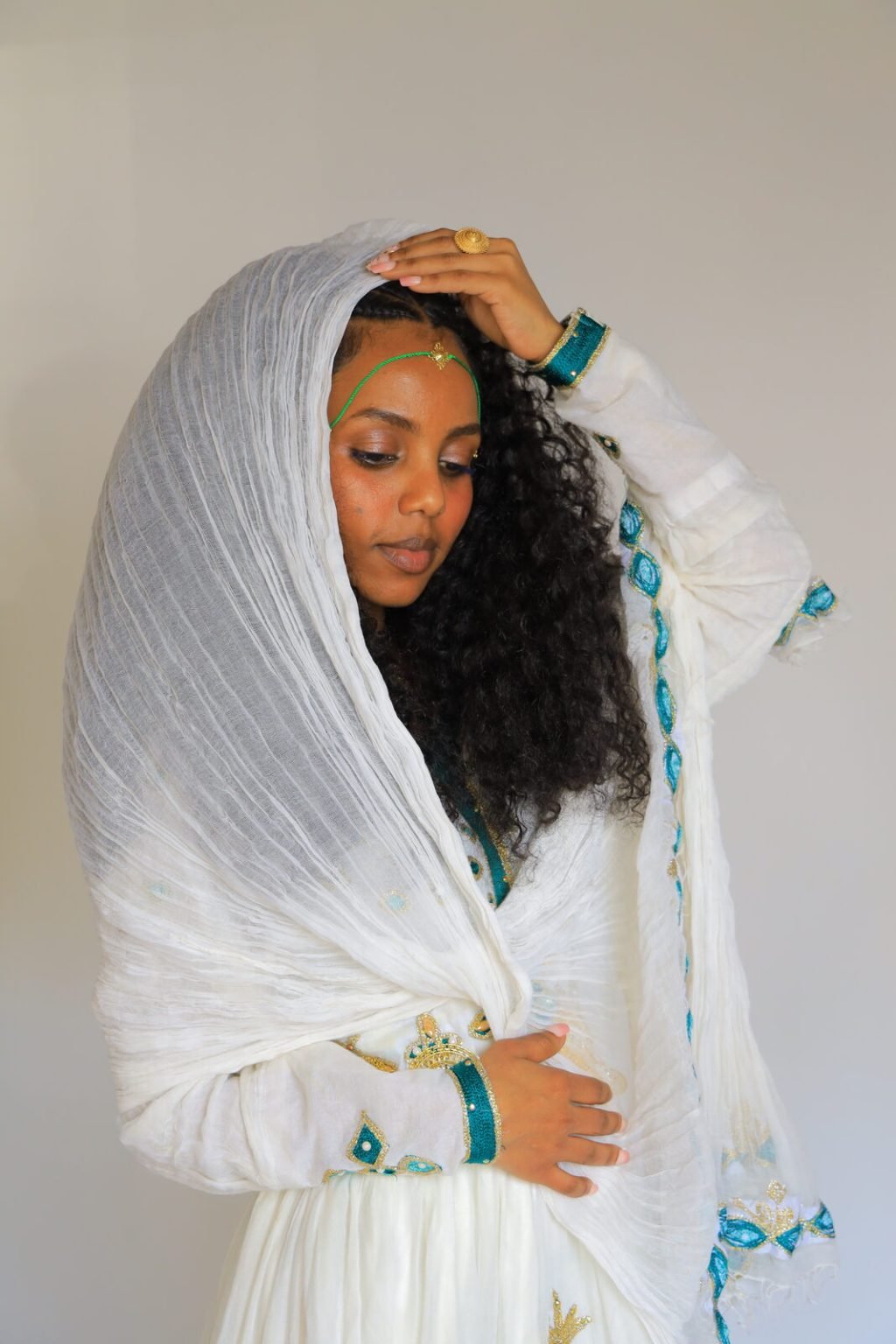 Portrait en studio, tenue traditionnelle blanche, la main dans les cheveux