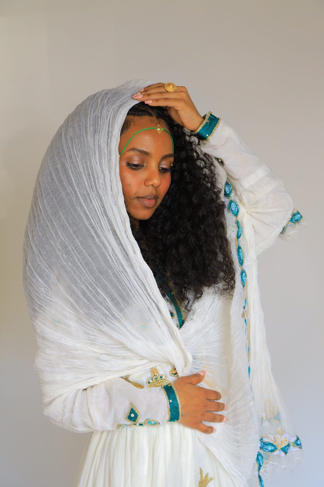 Portrait en studio, tenue traditionnelle blanche, la main dans les cheveux