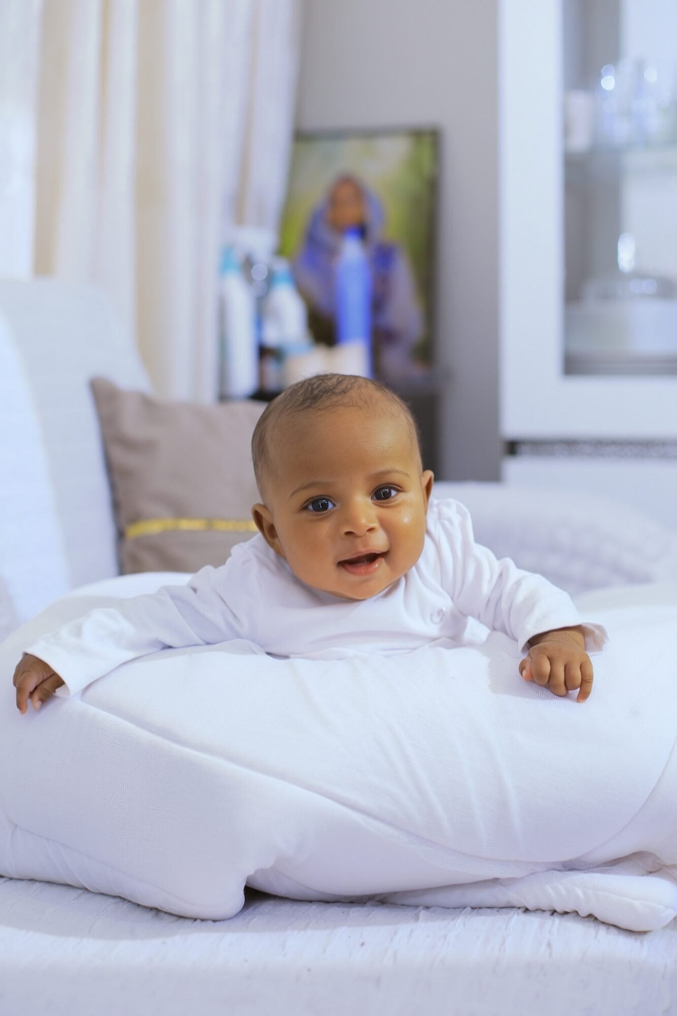 Bébé en tenue blanche allongé sur un coussin